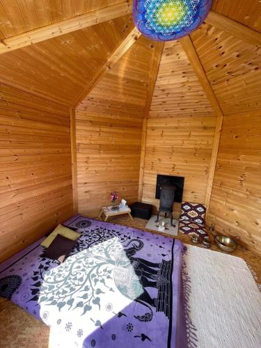 an attic room with a bed in a wooden cabin at namelis tyloje in Šarkiškės