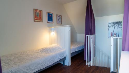 a small bedroom with two beds and a staircase at Sud Ocean L N94 2P4 in Guidel