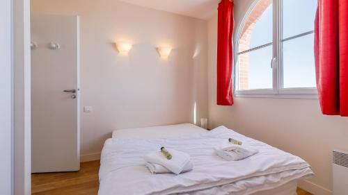 a bedroom with a white bed with two pillows on it at L Ocean N36 2P2 in La Tranche-sur-Mer