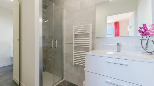 a white bathroom with a sink and a shower at L Ocean N36 2P2 in La Tranche-sur-Mer