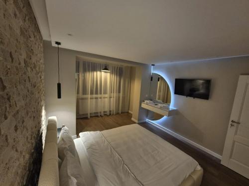 una camera da letto con un letto bianco e una tv di Alpasio Rentals 3 a Galaţi