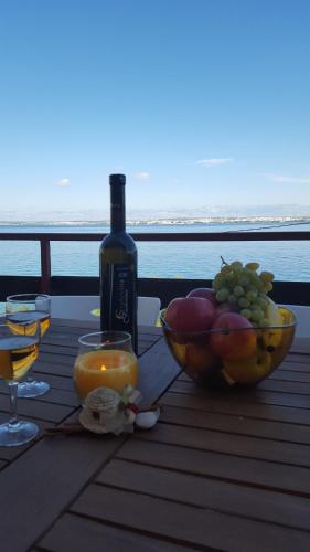 a table with a bowl of fruit and a bottle of wine at Apartment Ana in Kali