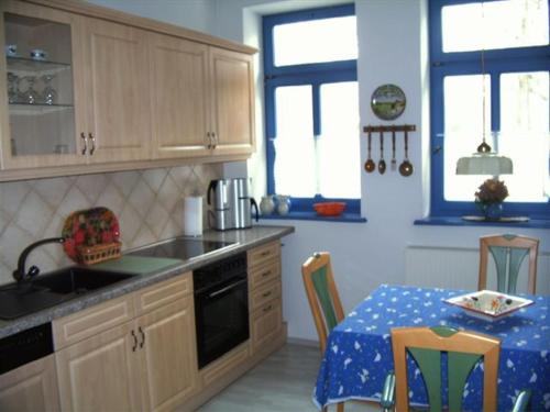 a kitchen with wooden cabinets and a table with a tableablish at Alter Ackerbuergerhof in Bad Frankenhausen