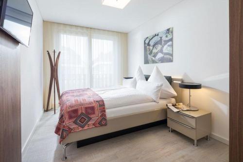 a bedroom with a bed with a nightstand and a window at Wohnart - Fewo 8 Wohnambiente in Norderney