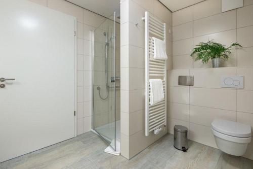 a bathroom with a toilet and a glass shower at Wohnart - Fewo 8 Wohnambiente in Norderney
