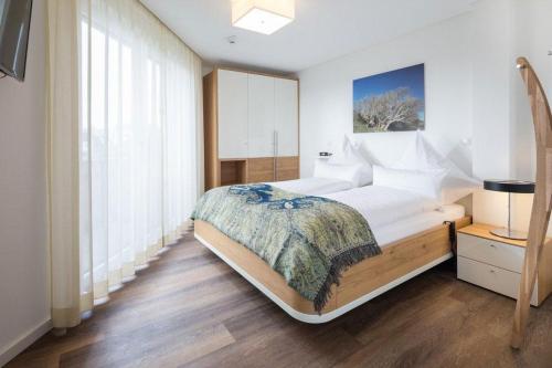 a bedroom with a large bed and a window at Wohnart - Fewo 6 Wohnkultur in Norderney