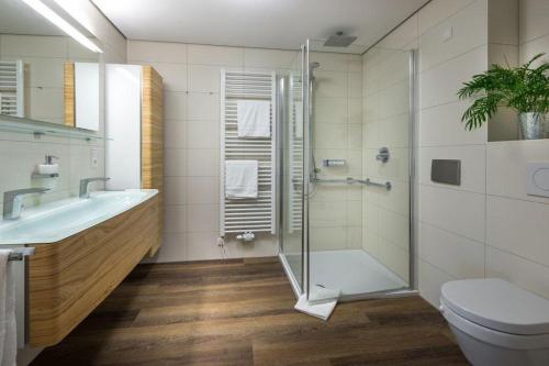 a bathroom with a shower and a toilet and a sink at Wohnart - Fewo 6 Wohnkultur in Norderney