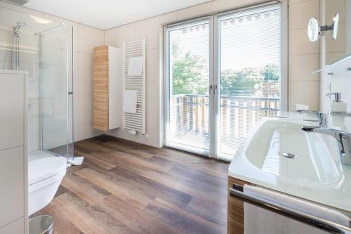 a bathroom with a sink and a toilet and a window at Wohnart - Fewo 1 Wohnstil in Norderney
