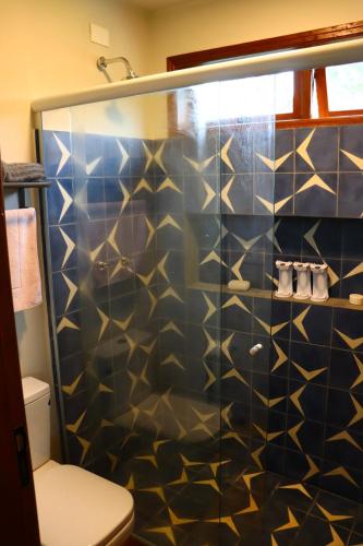 a bathroom with a shower with blue and gold tiles at Aura dos Ipês in Paraisópolis
