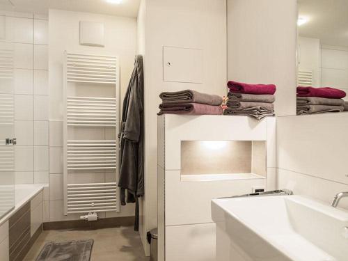 a white bathroom with a sink and a mirror at Ferienwohnung Meeresrauschen in Norderney