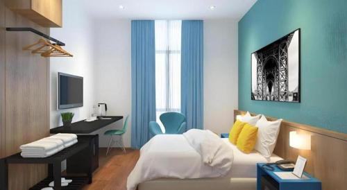 a bedroom with a bed and a desk with a computer at S Hotel in Johor Bahru