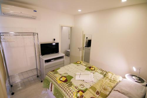 Dormitorio pequeño con cama y TV en Rio Spot Homes Copacabana U033, en Río de Janeiro