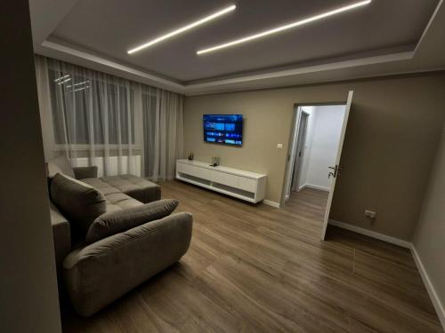 un soggiorno con un divano e una TV a parete di Alpasio Rentals 3 a Galaţi