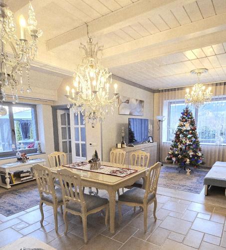 a dining room with a table and a christmas tree at Kristály Pihenőház in Szekszárd