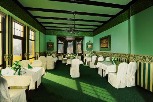 a dining room with white tables and white chairs at Hotel Orionka in Liberec