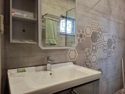 een badkamer met een witte wastafel en een spiegel bij 2 Bedroom Serviced Home in Lahore