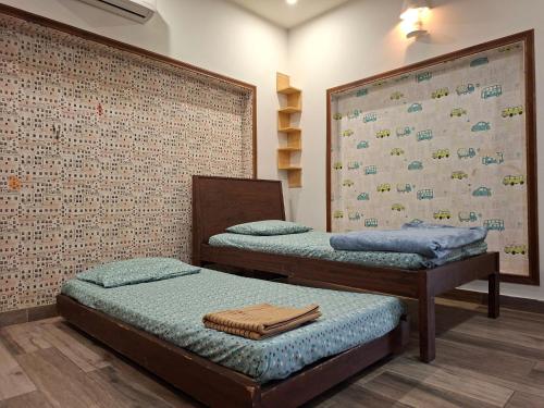 2 aparte bedden in een kamer met een muur bij 2 Bedroom Serviced Home in Lahore