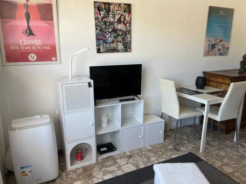 un salon avec une télévision et un bureau avec un ordinateur dans l'établissement Studio, à Cannes
