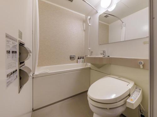 a bathroom with a toilet and a sink and a tub at Nishitetsu Hotel Croom Hakata in Fukuoka