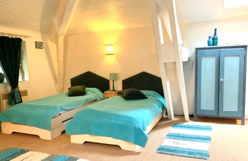 een slaapkamer met twee bedden en een lamp bij Le Castillou in Luc-sur-Aude