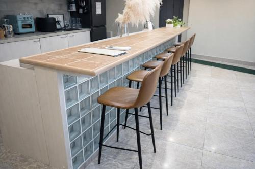 a kitchen with a counter with a row of stools at 金春 -in KONPAL Penthouse- in Kikuyo