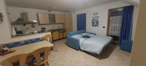 a living room with a bed and a kitchen at Casa Bedovina in Predazzo