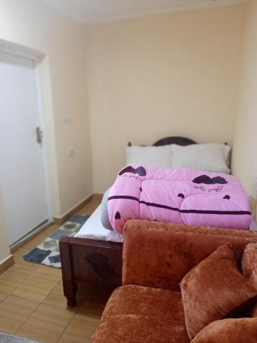 a bedroom with a bed with a purple blanket on it at EsMash Studio Machine lanet Nakuru in Nakuru