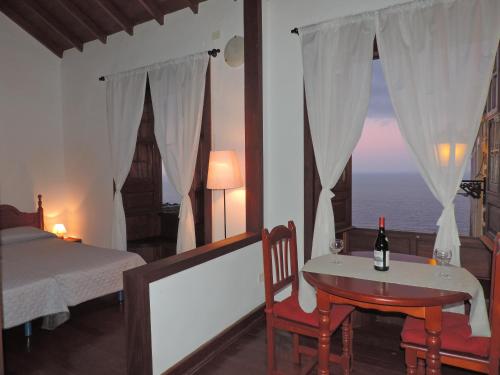 a bedroom with a bed and a table and a window at Casa Rural Los Helechos in Agulo