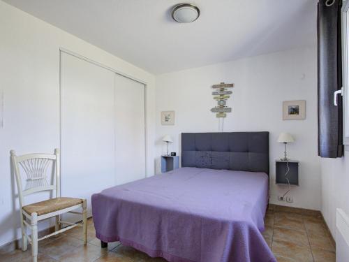 una camera con letto viola e sedia di Haut du Lac I N205 3P6 a Homps