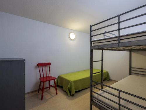 a bedroom with a bunk bed and a red chair at D du Ventoux D N55 3P6 in Aubignan