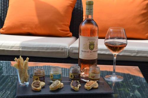 une bouteille de vin et un verre sur une table dans l'établissement Chalet Espace Lumière - Spa, sauna et salle de fitness, à Méolans