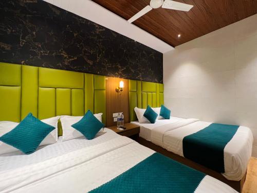 two beds in a room with green and white at Hotel Imperial Suite-Near BKC in Mumbai
