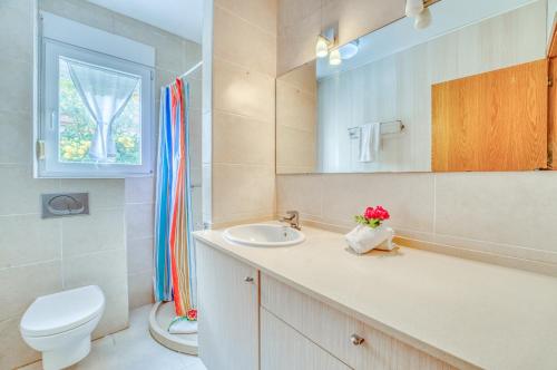 a bathroom with a sink and a toilet and a mirror at Ideal Property Mallorca - Villa Feel Good in Alcudia