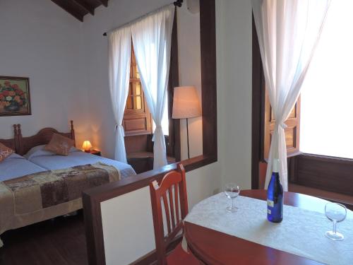 a bedroom with a bed and a table with wine glasses at Casa Rural Los Helechos in Agulo