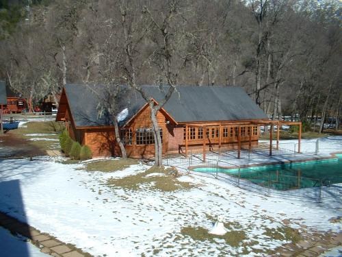 a log cabin with snow on the ground at Añañucas III in Las Trancas