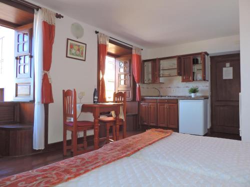 AguloにあるCasa Rural Los Helechosのベッドルーム1室(ベッド1台付)、キッチン(テーブル付)