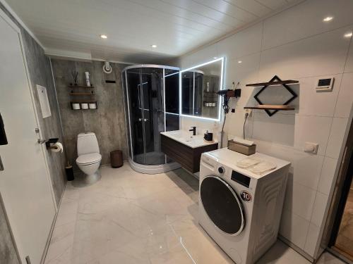 een badkamer met wastafel en wasmachine bij Nord Hus Service AS Nr 2 in Havøysund