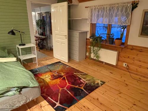 ein Schlafzimmer mit einem Bett und einem Teppich auf dem Boden in der Unterkunft Litet hus utanför Luleå in Luleå