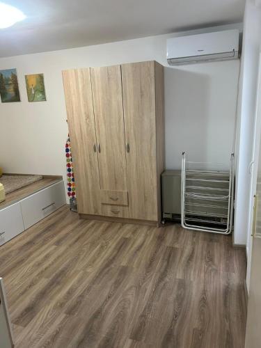 een lege kamer met een kast en houten vloeren bij Apartman Borkica in Mladenovac