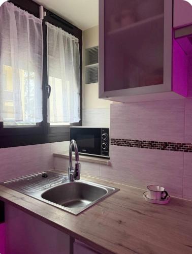 een keuken met een spoelbak en een magnetron bij Studio cosy et calme à Garches in Garches