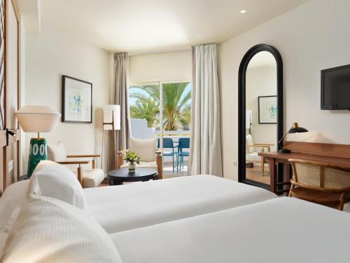 een slaapkamer met een bed en een woonkamer bij H10 Estepona Palace in Estepona