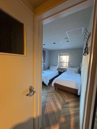 2 letti in una camera con porta aperta di Fuji Elegance Hotel a Yamanakako