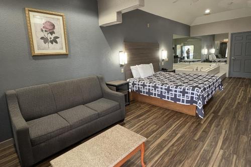 een hotelkamer met een bed en een bank bij Regency Inn & Suites By Capital O Houston IAH Airport in Humble