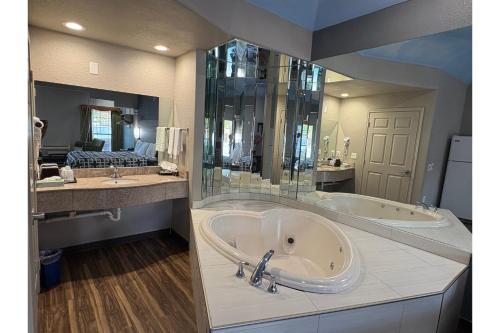 een grote badkamer met 2 wastafels en een bad bij Regency Inn & Suites By Capital O Houston IAH Airport in Humble