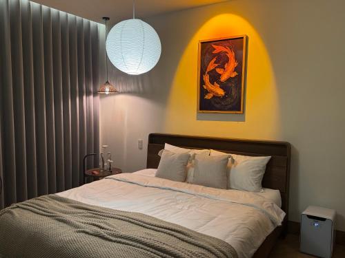 a bedroom with a bed with white sheets at GAJOs HOUSE in Thanh Xuân