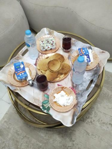 a table with plates of food and bottles of water at Queen House in Aswan