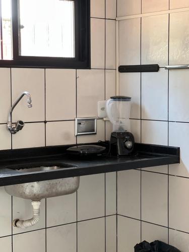 a kitchen with a counter top with a blender on it at 1 Quarto passos da praia in Fortaleza