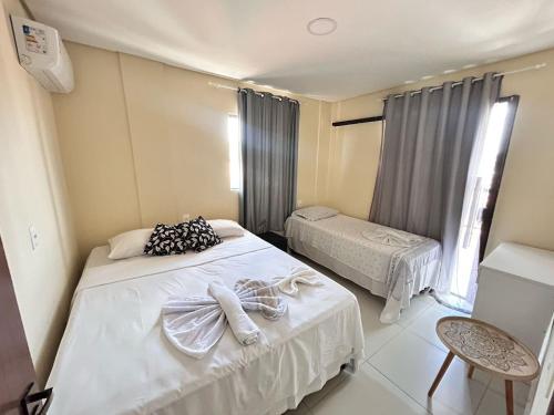 ein Schlafzimmer mit zwei Betten mit Handtüchern darauf in der Unterkunft Liszen flats in Porto De Galinhas