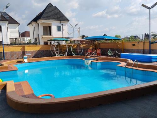 a large swimming pool with blue water in a building at 6A Resort in Owerri