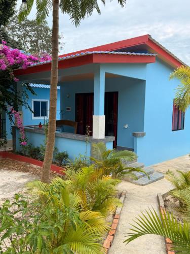 une maison bleue avec un toit rouge dans l'établissement Garden Hostel Koh Rong, à Sihanoukville